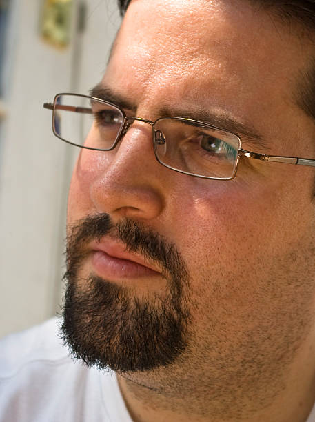 Man with beard and glasses looks intently