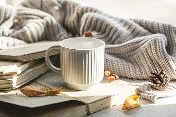 istock Autumn composition with a textured cup and a book on the windowsill. 1790878242