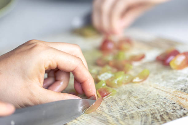 istock A woman cuts grapes on a cutting board. 1790893505