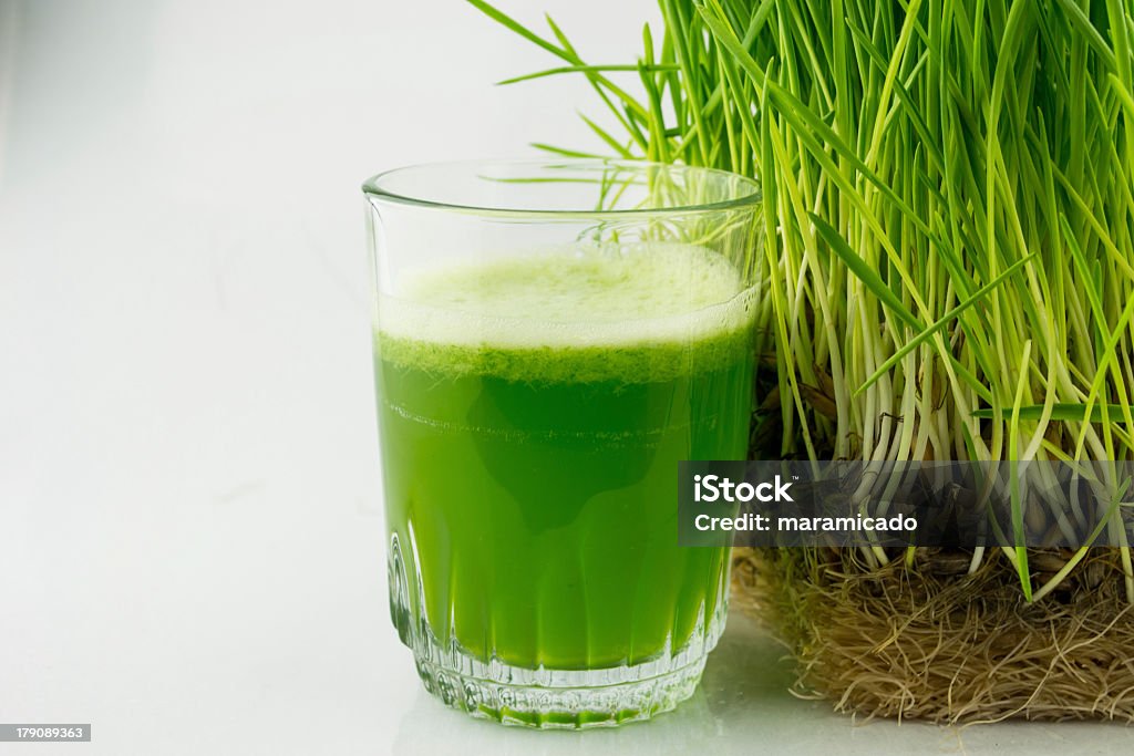 Green Organic Wheat Grass Juice beside a wheat grass plant Green Organic Wheat Grass Juice ready to drink Wheatgrass Stock Photo