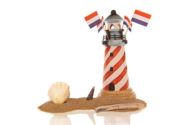 Lighthouse Dutch flags sea shells sand stock photo