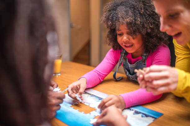 istock Mother and Two Daughters Enjoying Puzzles 1790901330
