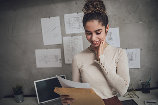 A young woman, reading a letter that has just arrived, has received a scholarship or an offer for a good job