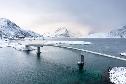 Bridge over the fjord. Aerial view of Lofoten Islands, Norway. Landscape in winter during the day. View from a drone. Aerial landscape. Mountains and water. Image of Norway