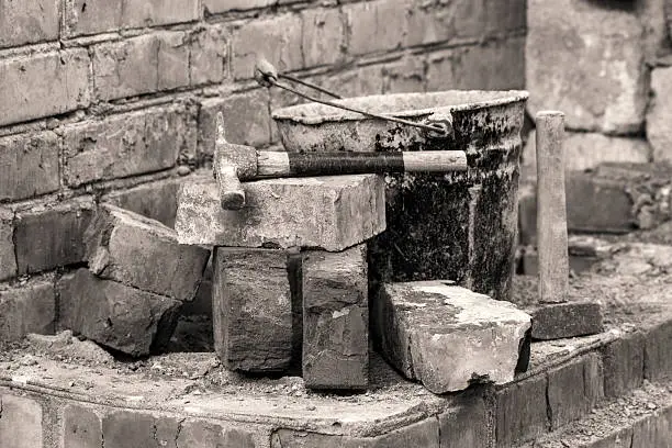 Bricks and elementary tools: hammers and the old rumpled bucket.