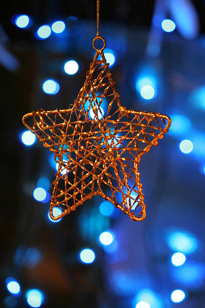 istock Gold star ornament with Christmas lights in background. 179091936