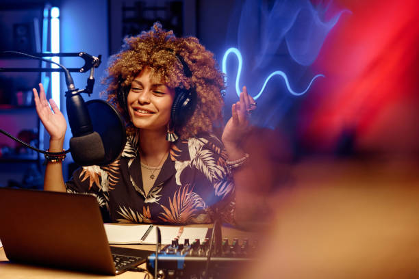istock Happy female host in headphones explaining something to online audience 1790927562