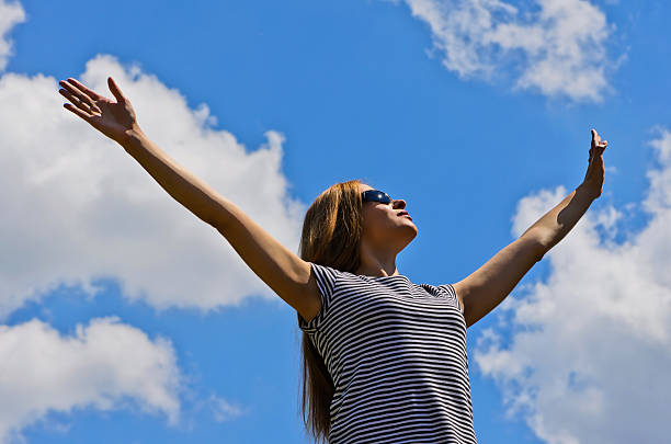 istock Girl with arms raised in sun glasses 179093405