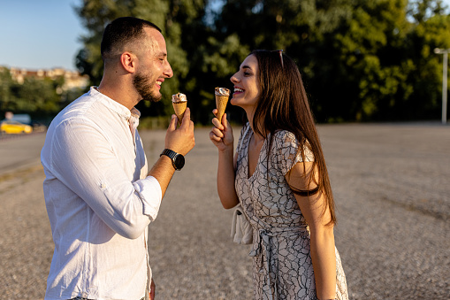 With their hearts aglow, the young couple shares ice cream moments, cherishing the warmth of their love in the cool treat