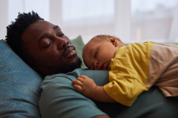 istock Exhausted father sleeping with cute little baby on chest 1790939342