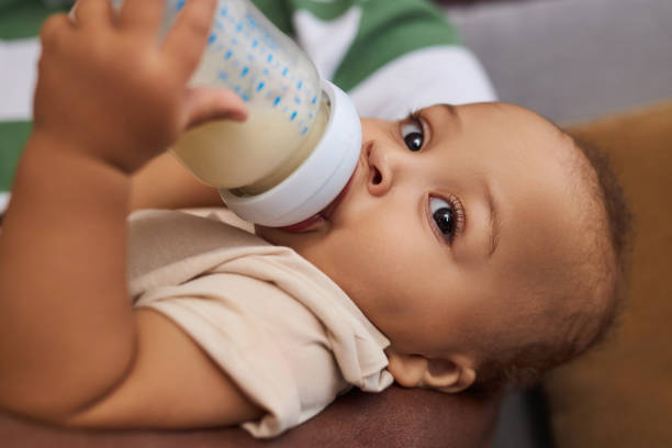 istock Close up cute Black baby boy drinking milk or formula from bottle 1790939421