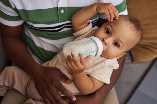 istock High angle cute baby boy drinking milk bottle and looking at camera 1790939509