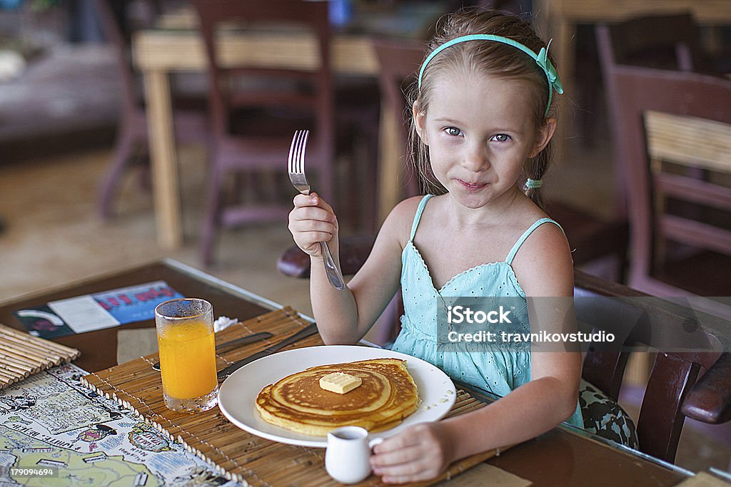 Little girl having breakfast with juice and pancake Little girl having breakfast with juice and pancake at resort restaurant Pancake Stock Photo