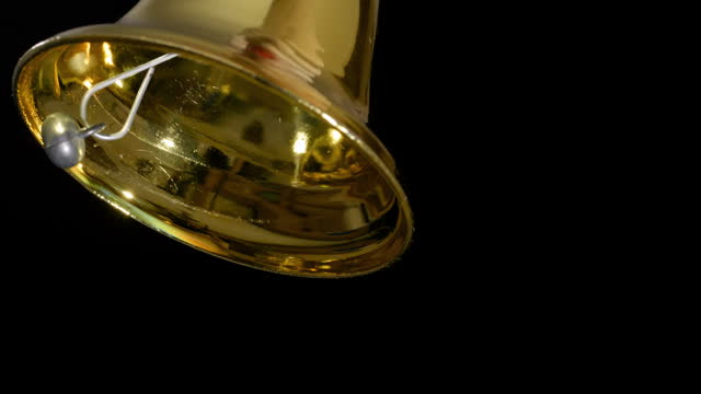 4K - Ring christmas bell. Slow motion. Close-up