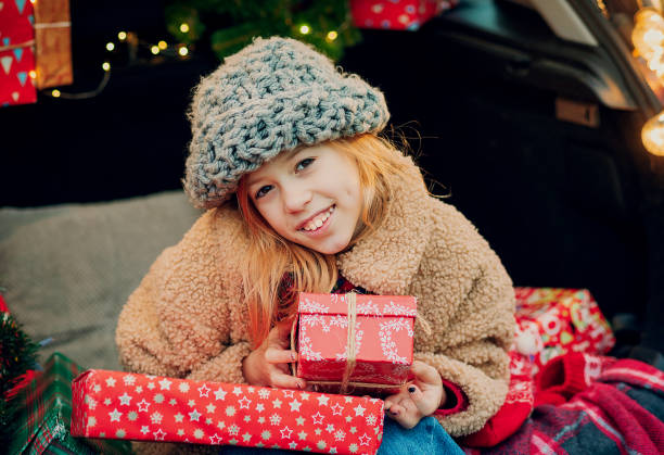 istock young girl holding large Christmas gift 1790967107