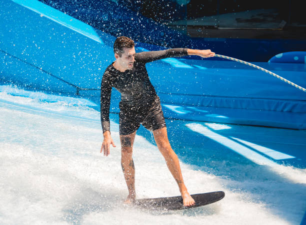 istock Young man surfing on a wave simulator at a water amusement park 1790971425
