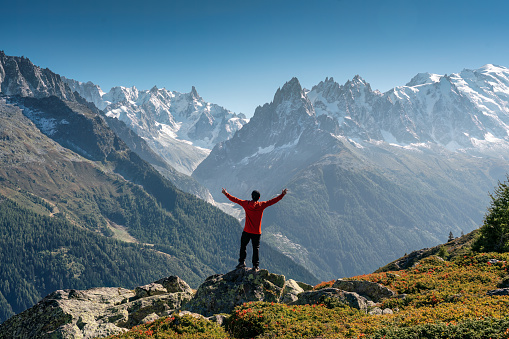 Achievement of male hiker standing with enjoying the Mont Blanc mountain range view during trail in Lac Blanc, French Alps, France