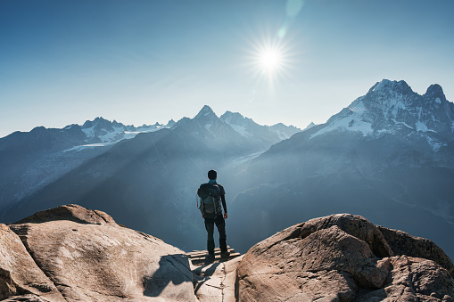 Achievement of male hiker standing with enjoying the Mont Blanc mountain range view during trail in Lac Blanc, French Alps, France