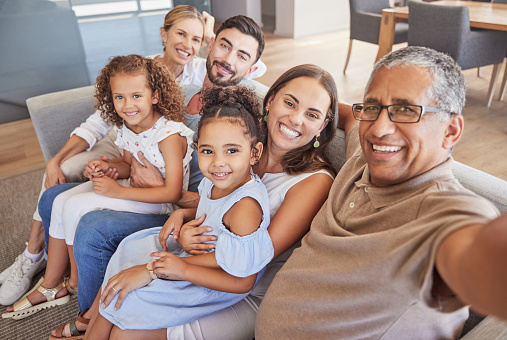 Selfie, family and children with a grandfather taking a photograph of his grandchildren and their parents at home. Kids, love and grandparents with a man and his relatives in the living room