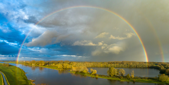 Rainbow during an autumn rain shower over the river IJssel near Zwolle in Overijssel, Netherlands.
