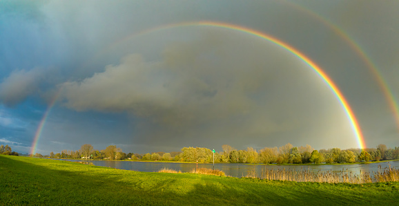 Rainbow during an autumn rain shower over the river IJssel near Zwolle in Overijssel, Netherlands.