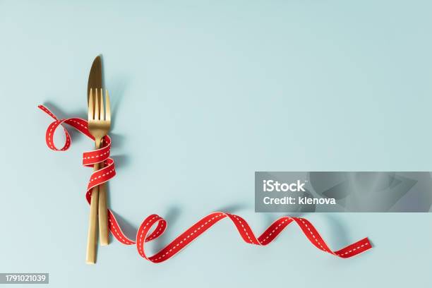 Fork And Knife Tied With A Red Ribbon Romantic Or Christmas Dinner Stock Photo - Download Image Now