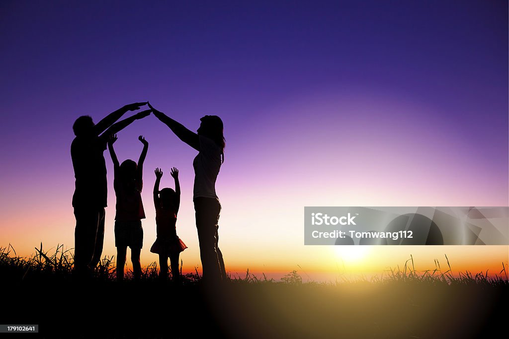 happy family making home sign on the hill happy family making home sign on the hill with sunrise background Family Stock Photo