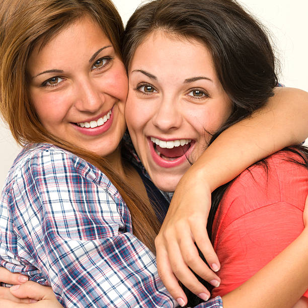 istock Caucasian sisters embracing, laughing at camera 179102717