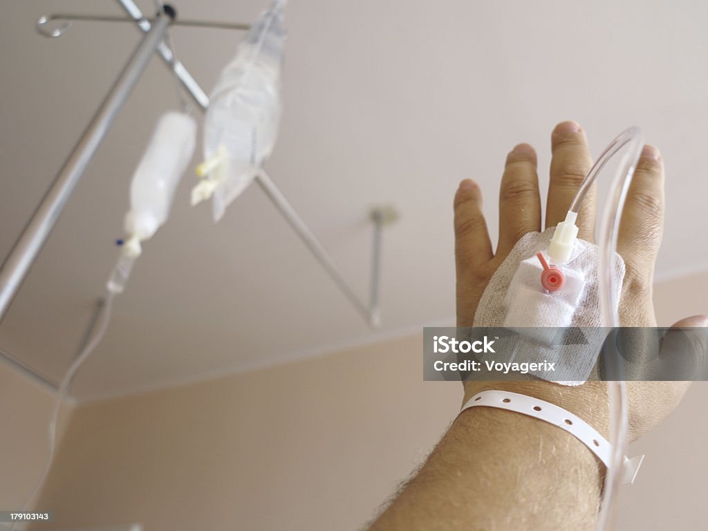 Patient's hand in the hospital with an IV Arm of a male patient in the hospital with an iv intravenous drip Healthcare And Medicine Stock Photo