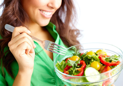 Fresh organic vegetables salad with quinoa seed in bowl holding by hand and eating on black background, Healthy Vegan food, Top view