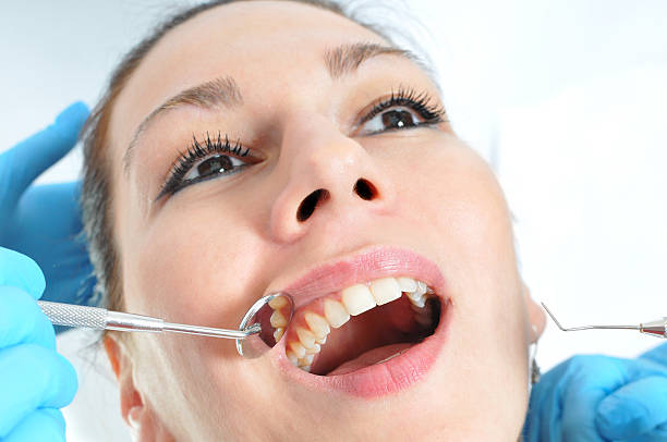 istock Cavity check up - dentist examining patients mouth and teeth 179104574