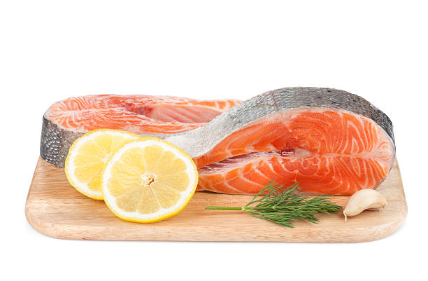 istock Salmon steaks on cutting board with lemons and herbs 179106469