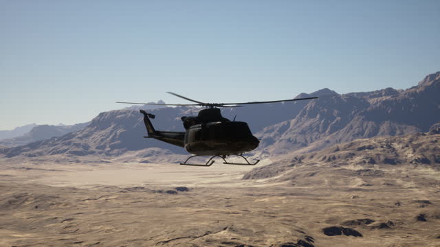 A helicopter flying over a mountain range in the desert