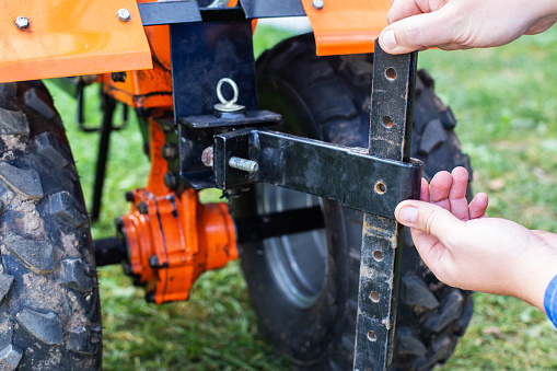 Adjustment of the coupling and attachments in a multifunctional motor cultivator for cottages.