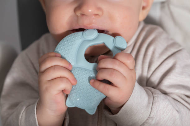 istock A child aged one year bites a blue medical teether. Concept massager for gums during teething in children. Excessive salivation, close-up 1791086088