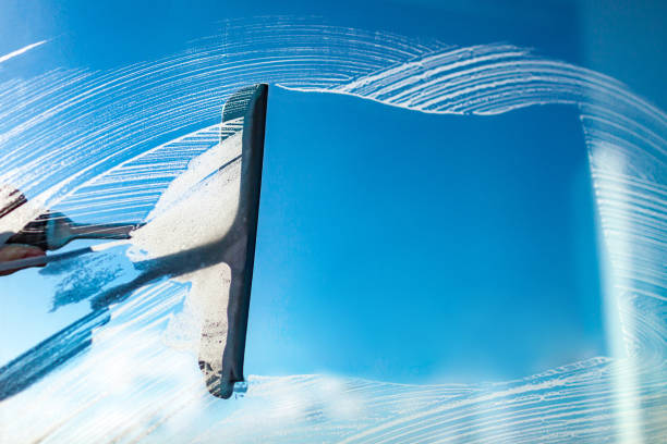 istock Cleaning windows with a squeegee on a blue sky background. Washing window 1791091595
