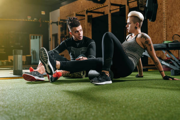 istock Athlete man and woman performing exercises for back with foam roller 1791096337