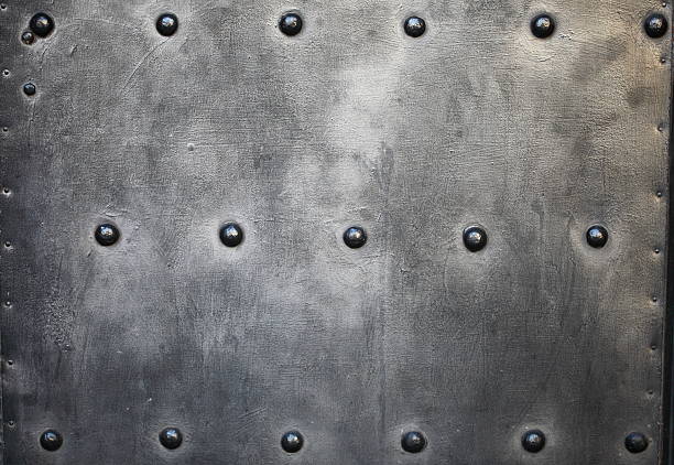 Black grunge metal plate or armour texture with rivets as background