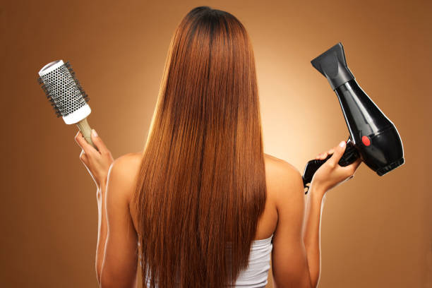 Hair, brush and hairdryer of woman in studio for growth and color shine or healthy texture. Aesthetic female hands with tools for haircare, self care and hairdresser or salon on brown background Hair, brush and hairdryer of woman in studio for growth and color shine or healthy texture. Aesthetic female hands with tools for haircare, self care and hairdresser or salon on brown background human hair women brushing beauty stock pictures, royalty-free photos & images