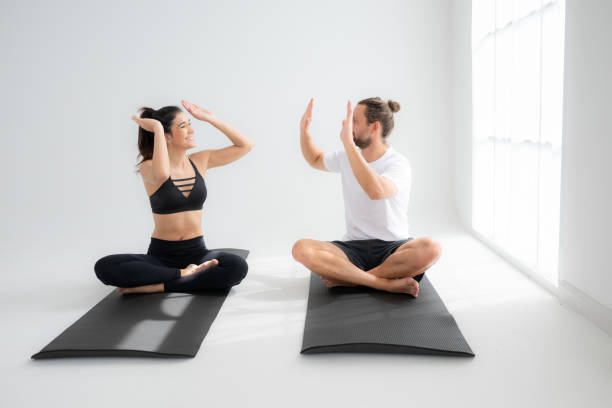 istock Young couple practicing yoga in a white room of studio. 1791101749
