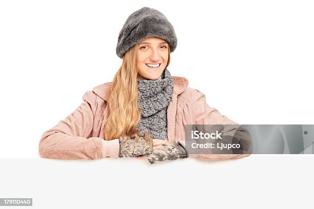 Sonriente Joven Mujer Posando Detrás De Un Panel Foto de stock y más banco de imágenes de 20 a 29 años - 20 a 29 años, Accesorio de cabeza, Accesorio para el cuello