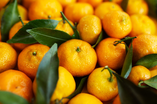 Juicy tangerines close-up with leaves as a background