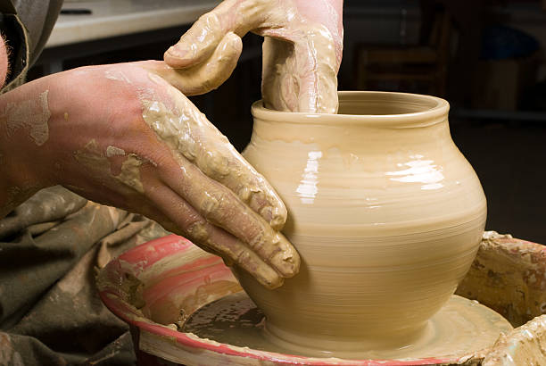 istock hands of a potter, creating an earthen jar 179110474