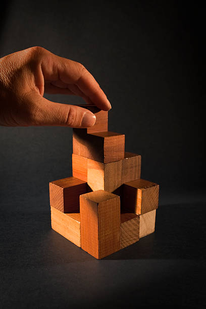 手のための木製ブロックパズル - cube puzzle three dimensional shape block ストックフォトと画像