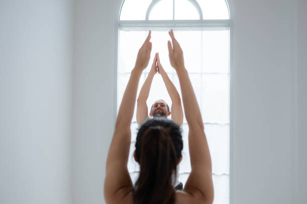 istock Young couple practicing yoga in a white room of studio. 1791115407