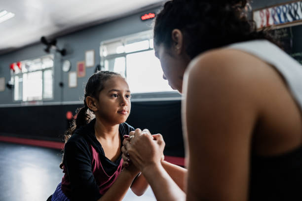 Child girl greeting her boxe instructor at gym