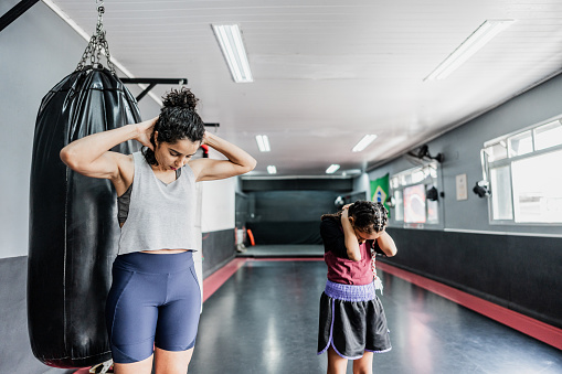 Mother and daughter stretching at boxe gym