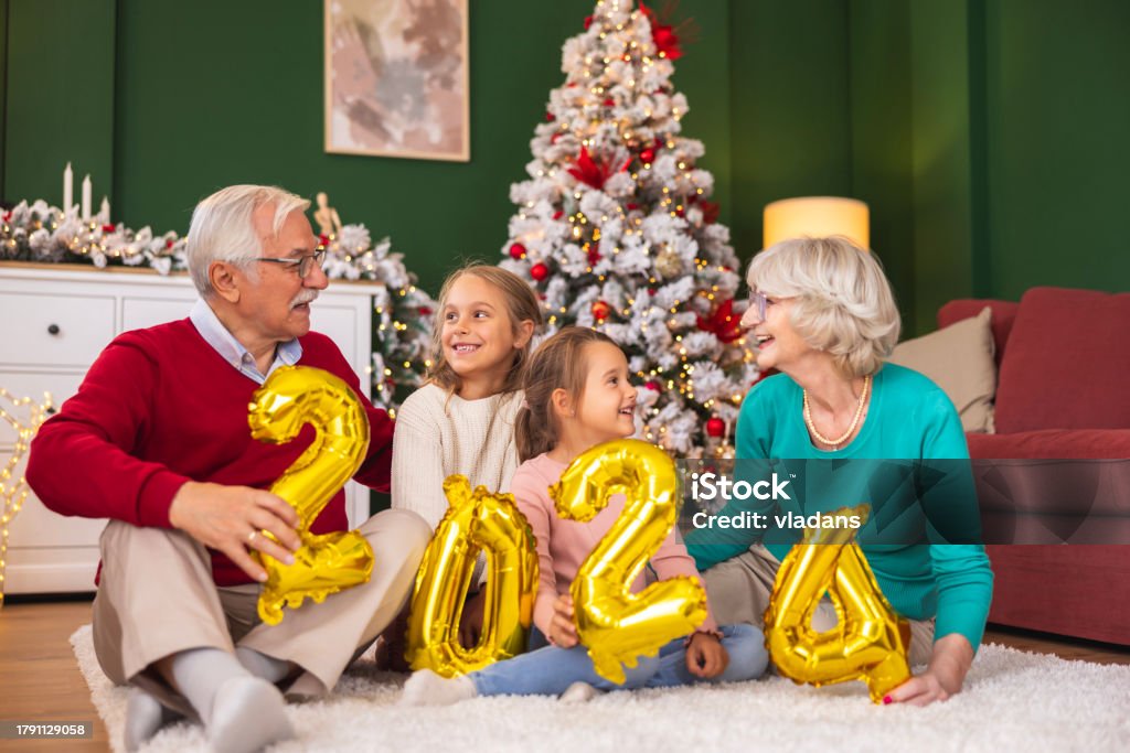 Grandparents Celebrating New Year With Grandchildren Holding 2025