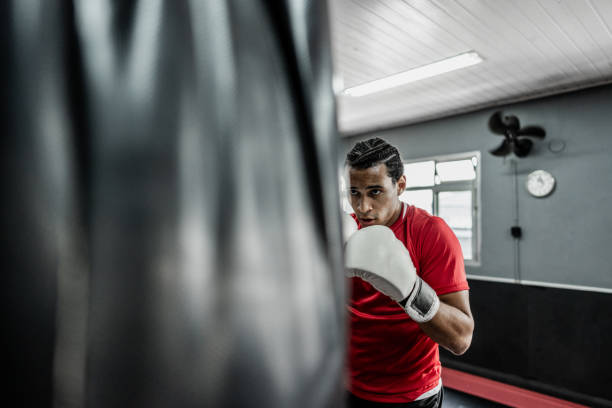istock Young man practicing boxe in a punching bag at gym 1791133620