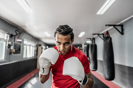 Portrait of a young man practicing boxing or muay thai at gym